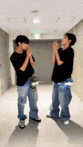 two men are standing in a hallway with their hands together