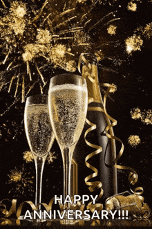 two glasses of champagne and a bottle of champagne with fireworks in the background saying happy anniversary !!!
