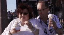 a man and a woman are eating ice cream outside