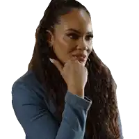 a woman with long curly hair is wearing a blue jacket and has her hand on her chin