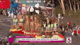 a parade with a float that says ' san diego zoo and wildlife alliance friendship across the earth ' on it