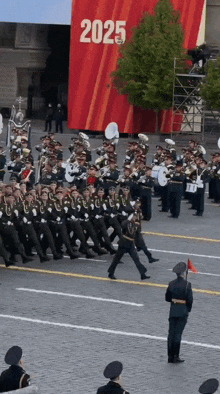 a band marching in front of a sign that says 2025 on it