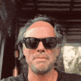 a man wearing sunglasses is making a funny face .