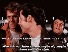 a group of men are standing next to each other and one of them is talking to another man .