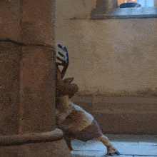 a stuffed animal with antlers is standing next to a stone wall .