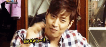 a man wearing a plaid shirt says bravo !!