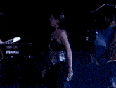 a woman standing in front of a yamaha ex7 keyboard