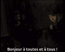 a man in a dark room with the words bonjour a toutes et a tous