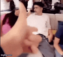 a group of people are sitting on a couch and a man is giving a thumbs up sign .