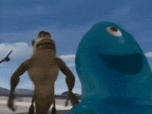 a monkey and a blue monster are standing next to each other on a beach .