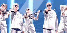 a group of young people are playing violins and singing into microphones on a stage
