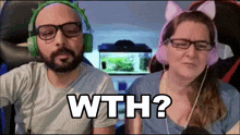 a man and a woman wearing headphones are sitting next to each other and the woman is wearing cat ears