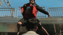 a man wearing a red jacket with the number 10 on the front