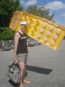 a woman wearing a tank top that says o'neill is holding a large inflatable raft