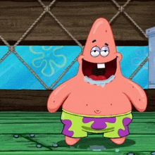 patrick star from spongebob squarepants is standing on a wooden floor