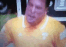 a blurry picture of a man wearing a yellow shirt with a white collar