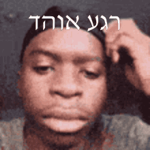 a close up of a man 's face with hebrew writing on the bottom right