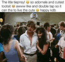 a man and a woman are dancing in front of a crowd of people .