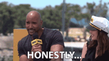 a man with a microphone says honestly while sitting next to a woman in a captain 's hat