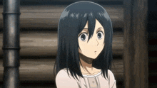 a girl with black hair is standing in front of a wooden wall