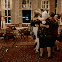 a group of people hugging each other in a room