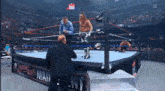 a wrestler is standing in a wrestling ring with a referee