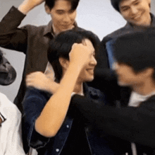 a group of men are hugging each other and one of them is holding his fist to his face .