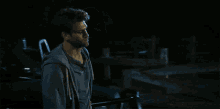 a man and woman are looking at each other in a dark room .