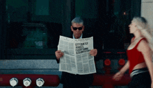 a man is reading a newspaper which says city quietly agrees everything is slightly off
