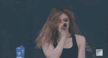 a woman singing into a microphone with a sign behind her that says magenta musik 360