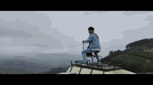 a man is sitting on top of a building with a view of mountains