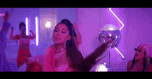 ariana grande is dancing in a purple room in a video for her new song .