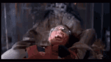 a person is laying on a bed with a monster behind them .