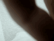 a close up of a person 's arm with a shadow on a white surface .