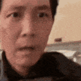 a man with a surprised look on his face is looking at the camera .