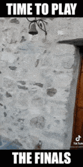 a stone wall with a bell on it and the words time to play the finals below it