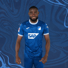 a man wearing a blue shirt with the word sap on the front