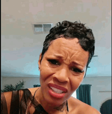a woman with short hair is making a funny face in a living room