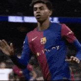 a soccer player wearing a blue and red jersey with the word fcb on it