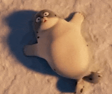 a cartoon seal is laying on its back on the snow .