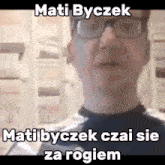 a man wearing glasses and a black shirt with the words mati byczek