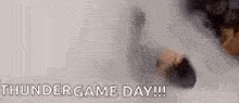 a man is standing in a cloud of smoke with the words `` thundergame day '' written on it .