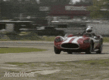 a red and white race car is driving on a track with motorweek written in the corner
