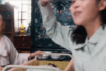 a woman in a blue shirt is holding a rope