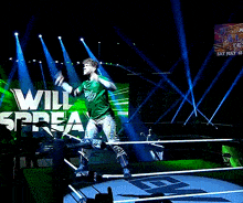 a wrestler in a green shirt screams in front of a sign that says aew all texas