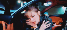 a woman in a striped shirt is sitting in a car with the words pinked out written on the bottom