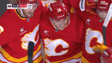 a hockey player with the number 16 on his helmet is surrounded by his teammates