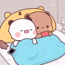 two teddy bears are laying on a bed with a blanket .