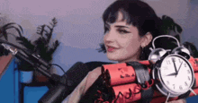 a woman is holding a bomb with an alarm clock on it .