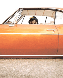 a cartoon character is peeking out of an orange car